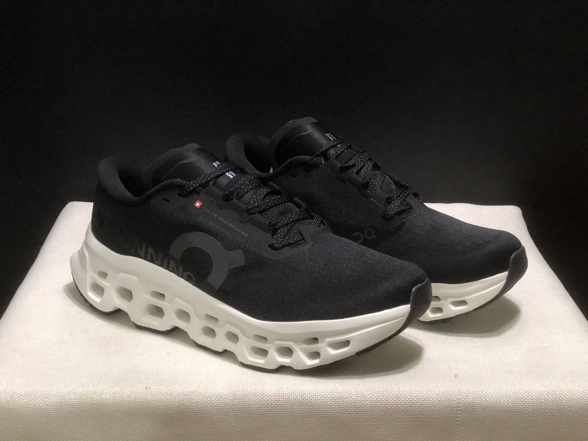 Three-quarter view of the black and white running sneakers with lace-up uppers and sculpted midsoles.