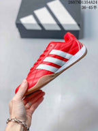 Side profile of the red low-top sneaker with white stripes and a gum-colored outsole.