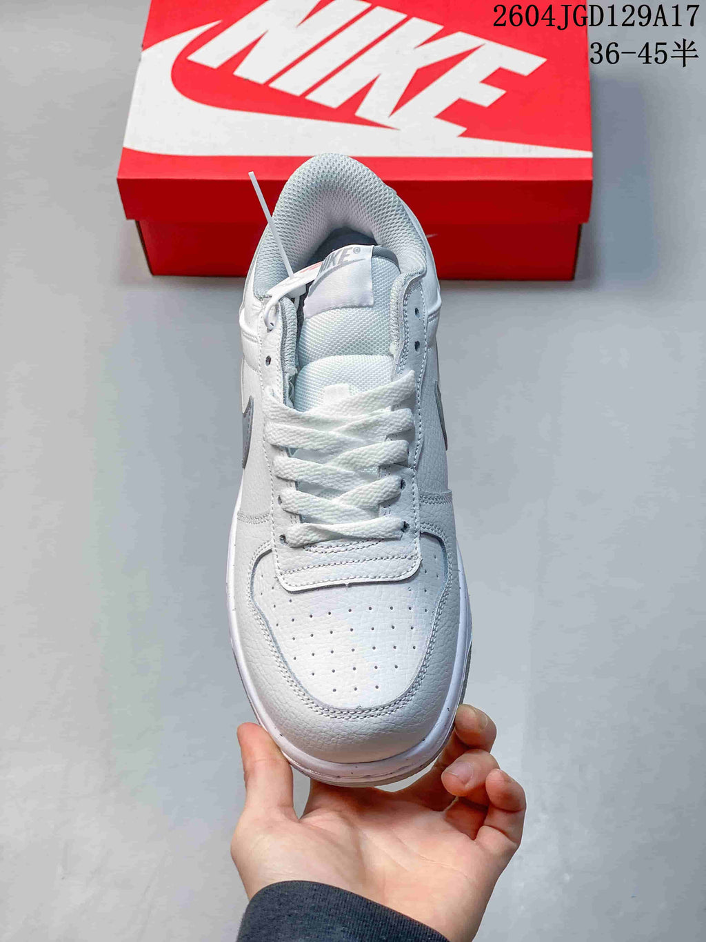 Top view of a white and grey lace-up sneaker with perforated toe