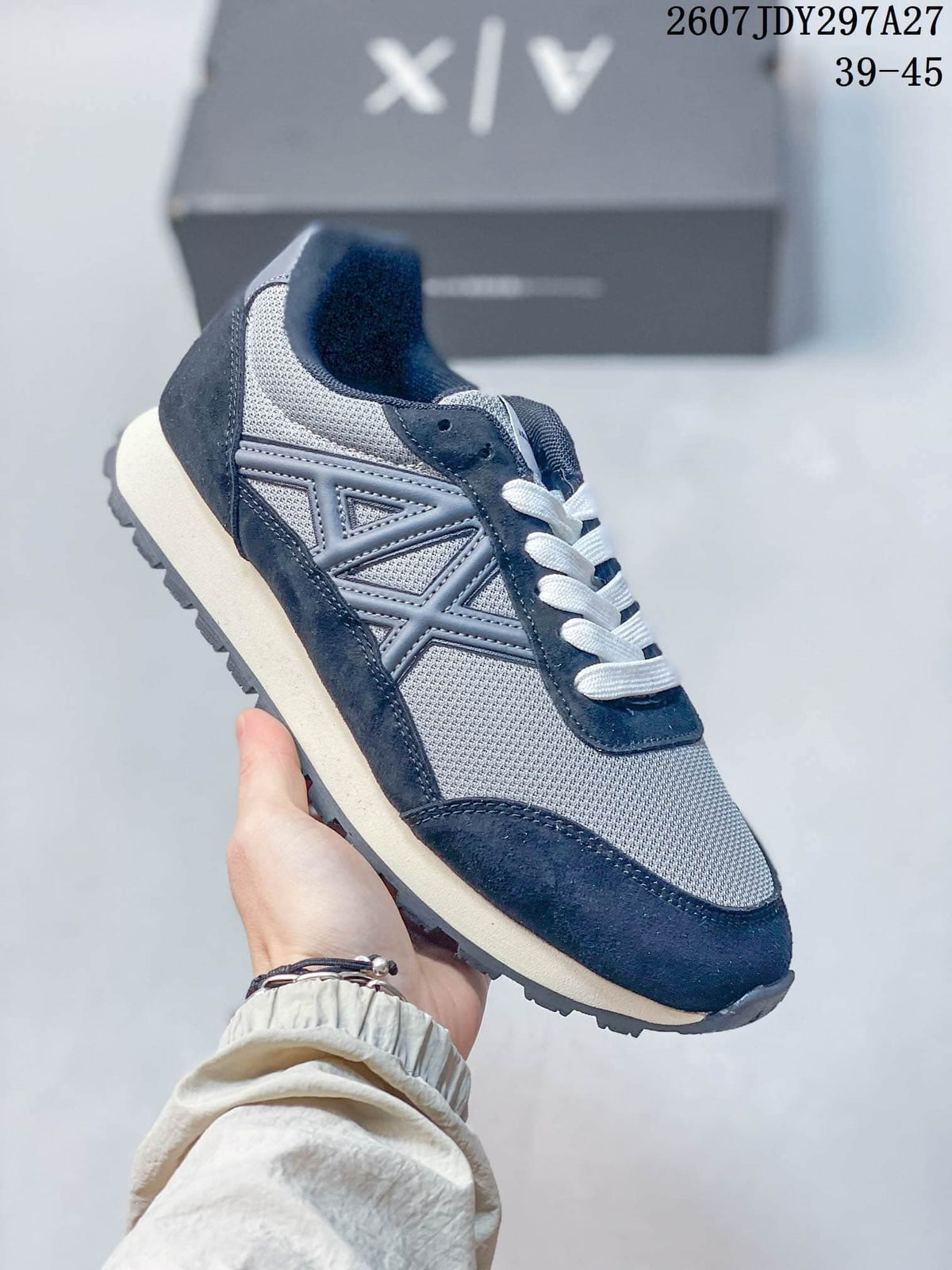 Dark navy and gray low-top sneaker with white laces and layered side panels.