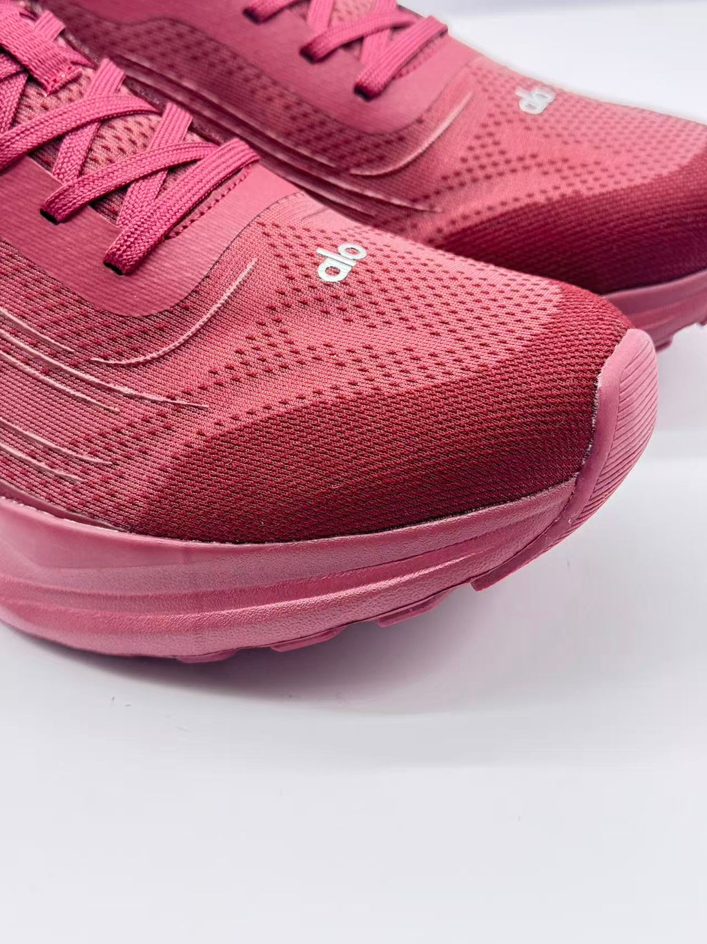 Close-up of the textured burgundy toe box, laces, and white alo branding.