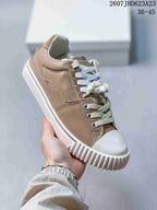 Angled side view highlighting the taupe canvas and leather-look panels, white laces, and thick rubber sole.