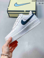 Side view of the white low-top sneaker with navy Swoosh and textured sole