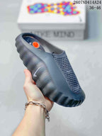 Dark gray Nike Mind 001 slip-on slide with a closed toe, perforated upper, and rugged textured outsole.