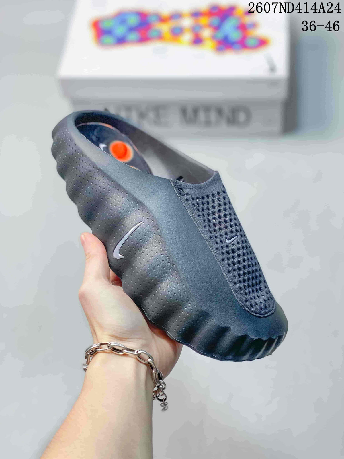 Dark gray Nike Mind 001 slip-on slide with a closed toe, perforated upper, and rugged textured outsole.