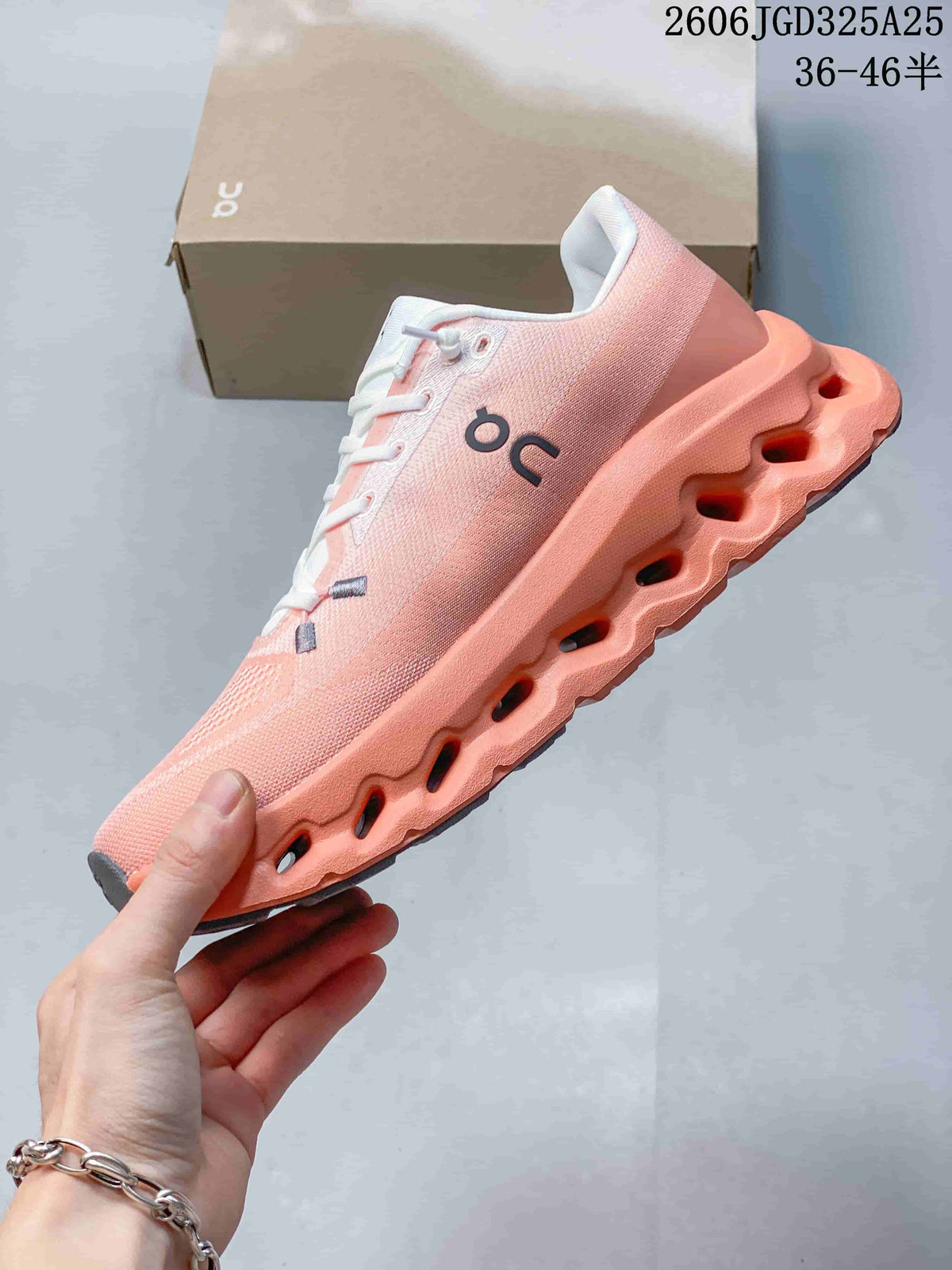 Side profile of the pink and coral On Cloudsurfer sneaker showing the lace-up upper and sculpted sole with open channels.