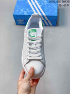 Top view of the sneaker with white laces and a green tongue label