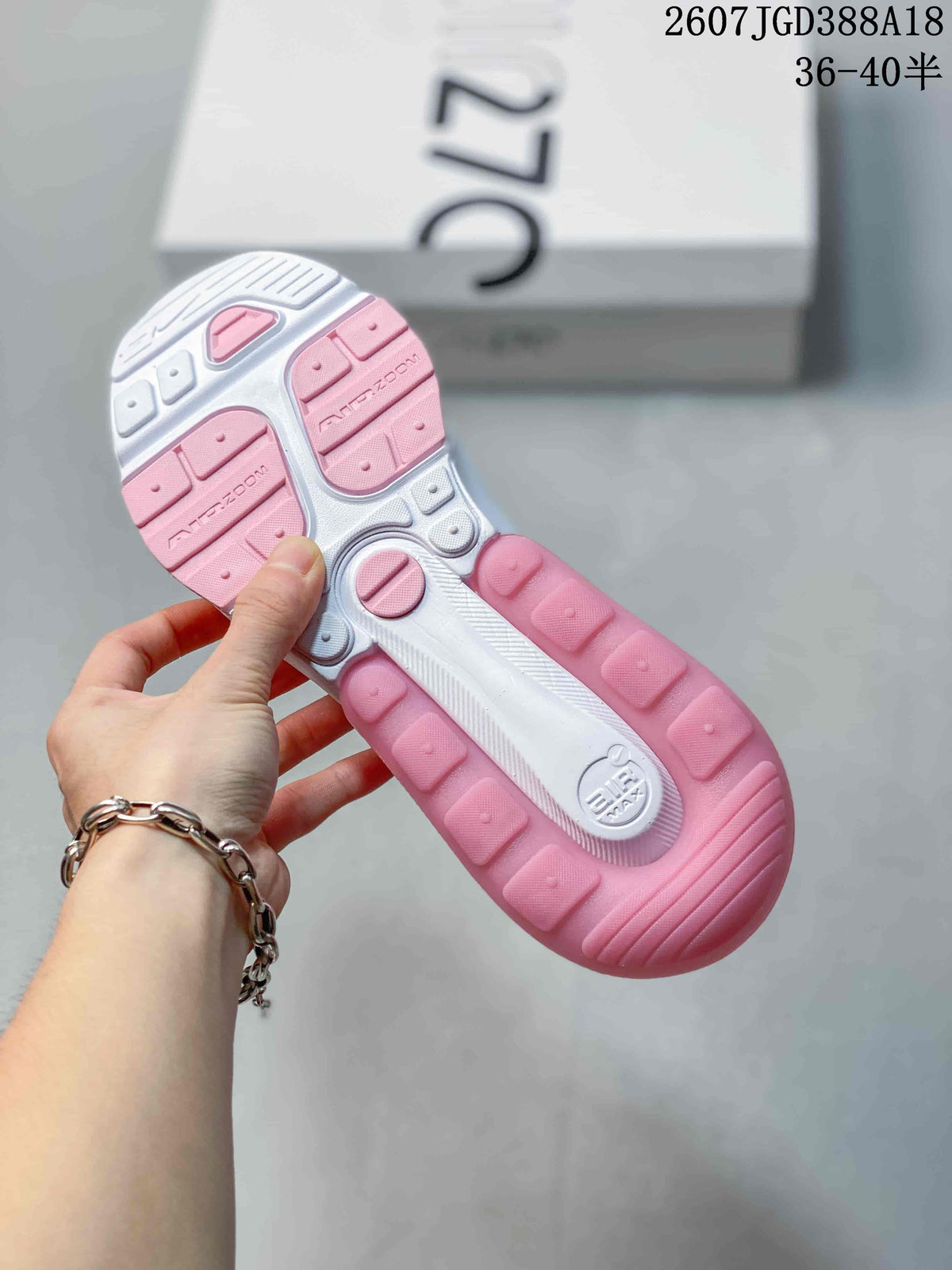 Underside view of the sneaker showing a white and pink outsole with segmented tread and Air Max branding.