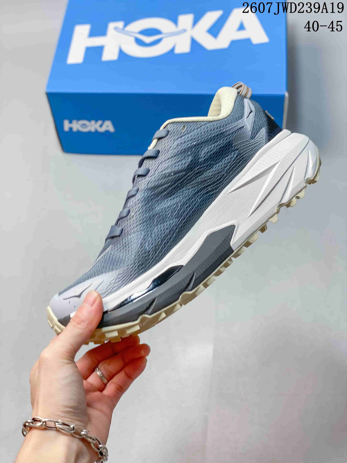Side profile of the gray low-top running shoe showing the mesh-textured upper, white midsole, and cream outsole.