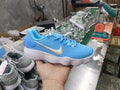 Blue Nike lace-up sneaker with a metallic silver Swoosh and white ridged sole