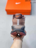 Rear view of the brown sneaker showing the heel, orange logo detail, and layered black midsole.