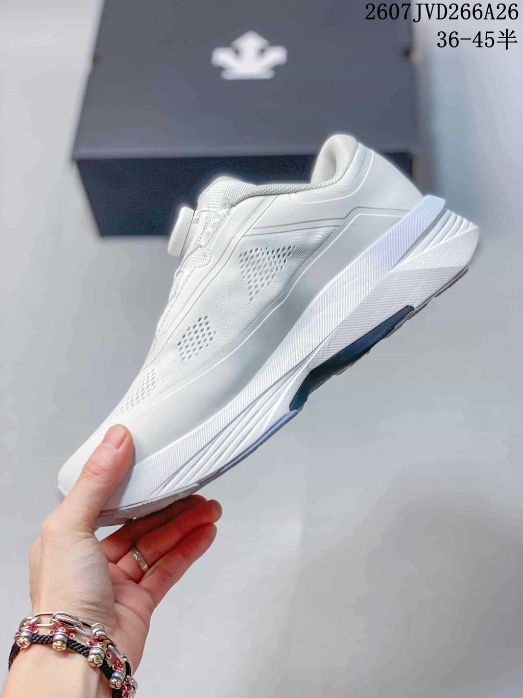 Side view of the white sneaker showing perforated upper panels, geometric overlays, and a raised midsole.