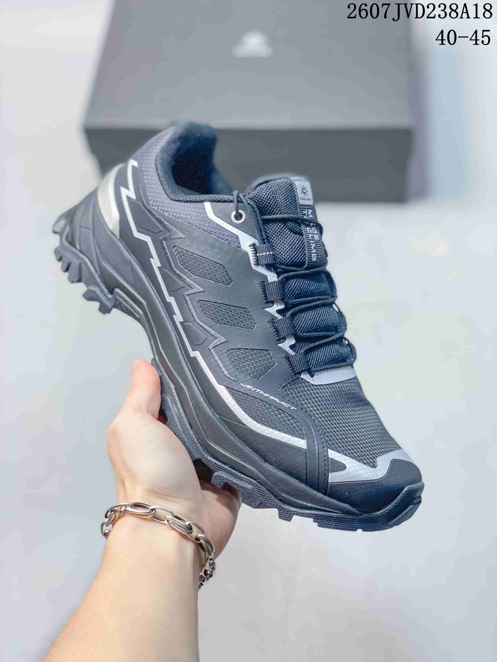 Three-quarter side view of the Kailas low-top hiking shoe showing its dark upper, layered panels, and lugged sole.