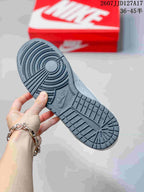 Underside view of the sneaker showing the dark textured rubber outsole and circular traction pattern.