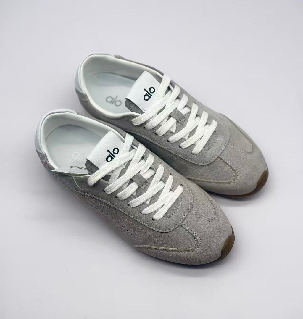 Top three-quarter view showing the gray uppers, white laces, tongue branding, and insoles.