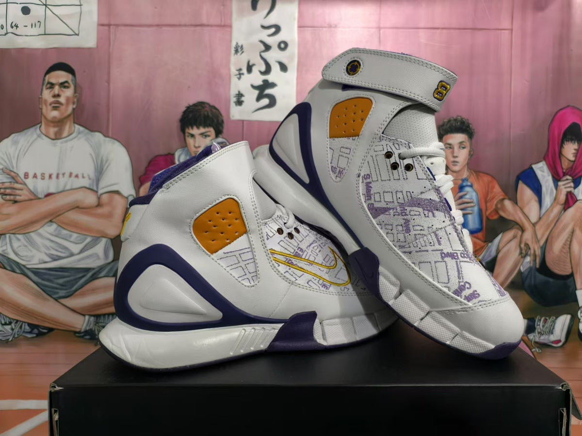 Pair of white, purple, and gold high-top basketball sneakers with forefoot straps and map-style graphics.