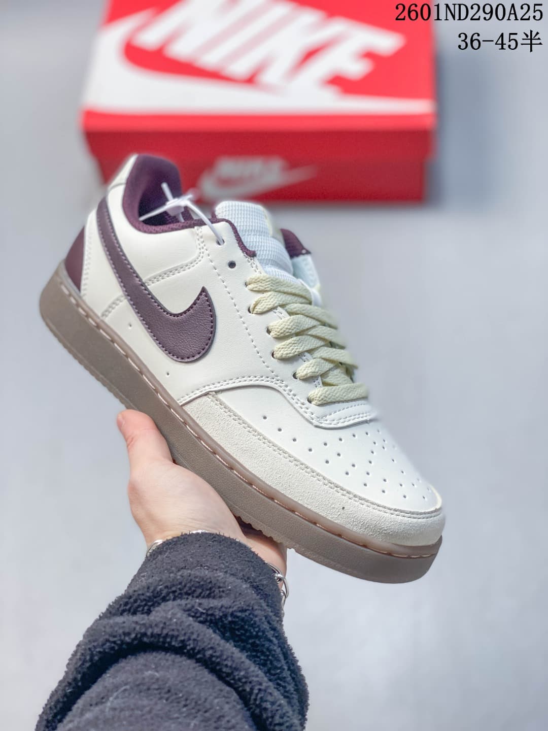 Close-up of an off-white low-top sneaker with a muted purple Swoosh and taupe outsole.