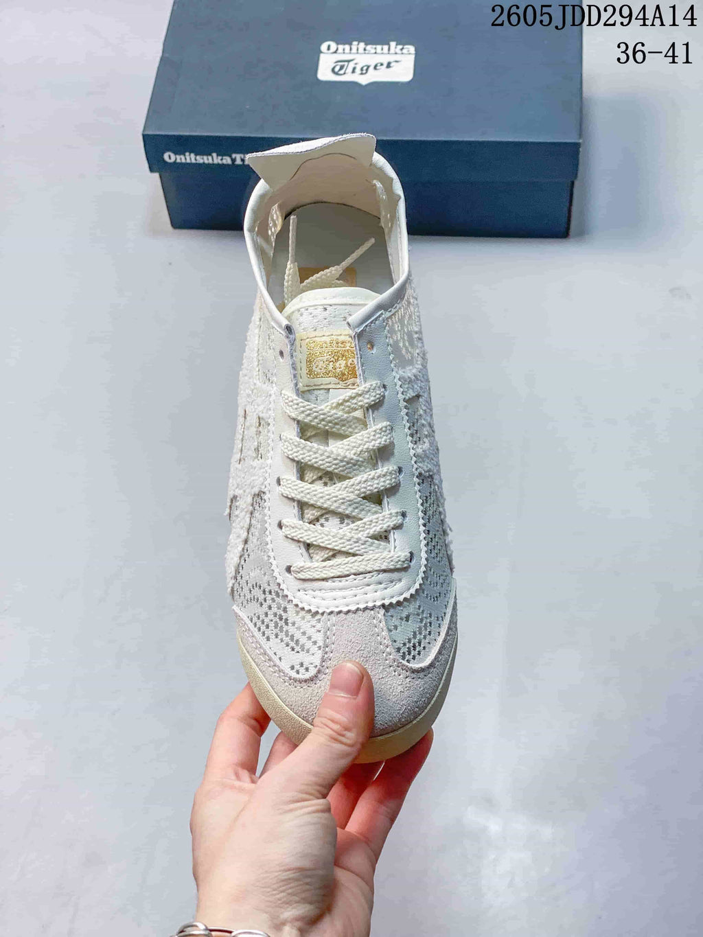 Top view of the sneaker showing white laces, layered toe panels, and contrasting grey patterned side details.