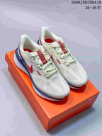 Pair of white Nike running sneakers with red and blue accents displayed on an orange shoebox.