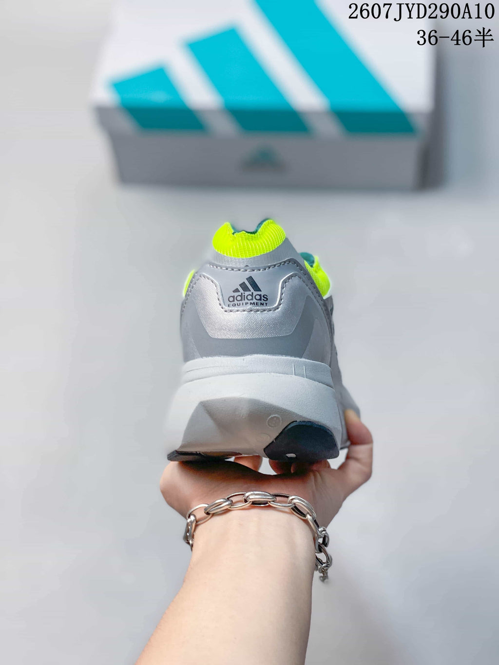 Rear view of the adidas Equipment Adios Pro shoe showing the grey heel, neon yellow collar accent and adidas Equipment branding.