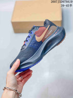 Side view showing the textile-style upper, tan and red side accents, white swoosh and sculpted dark midsole.