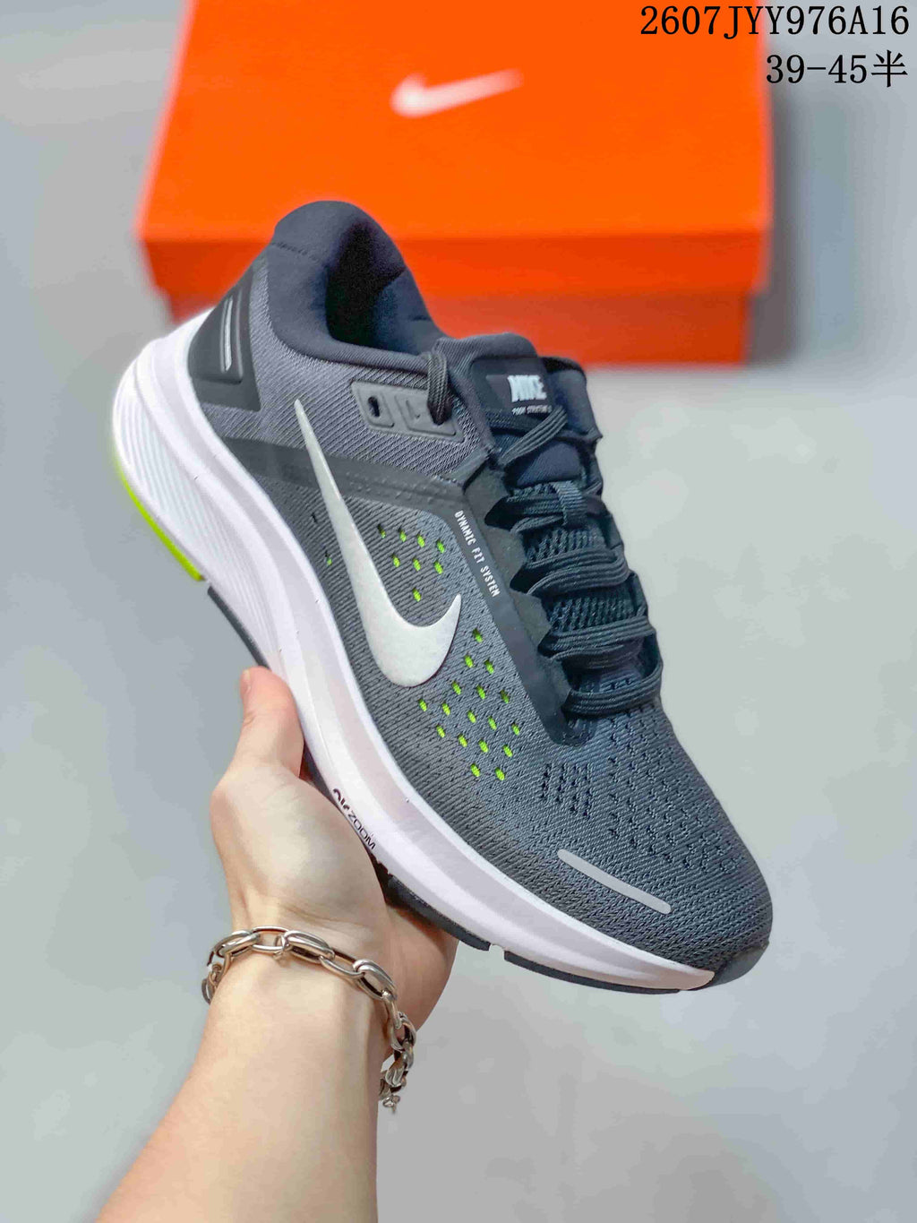 Angled side view of the gray Nike sneaker showing the white Swoosh, mesh upper, padded collar, white midsole, and neon green outsole accents.