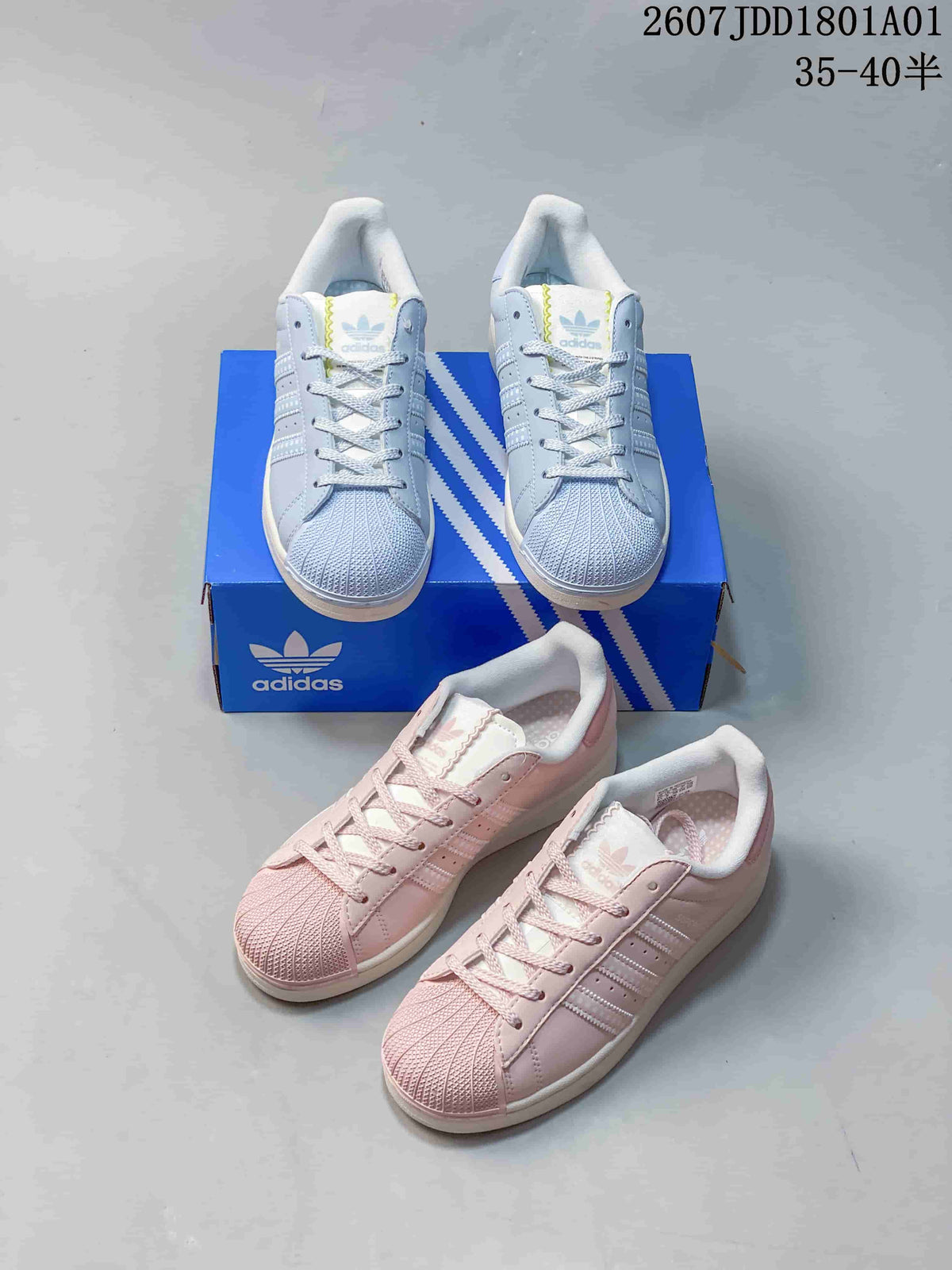 Pastel blue and pink Adidas Superstar sneakers photographed with a blue shoebox