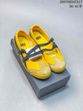 Pair of yellow Onitsuka Tiger MEXICO 66 sneakers with black double straps displayed on a shoebox.