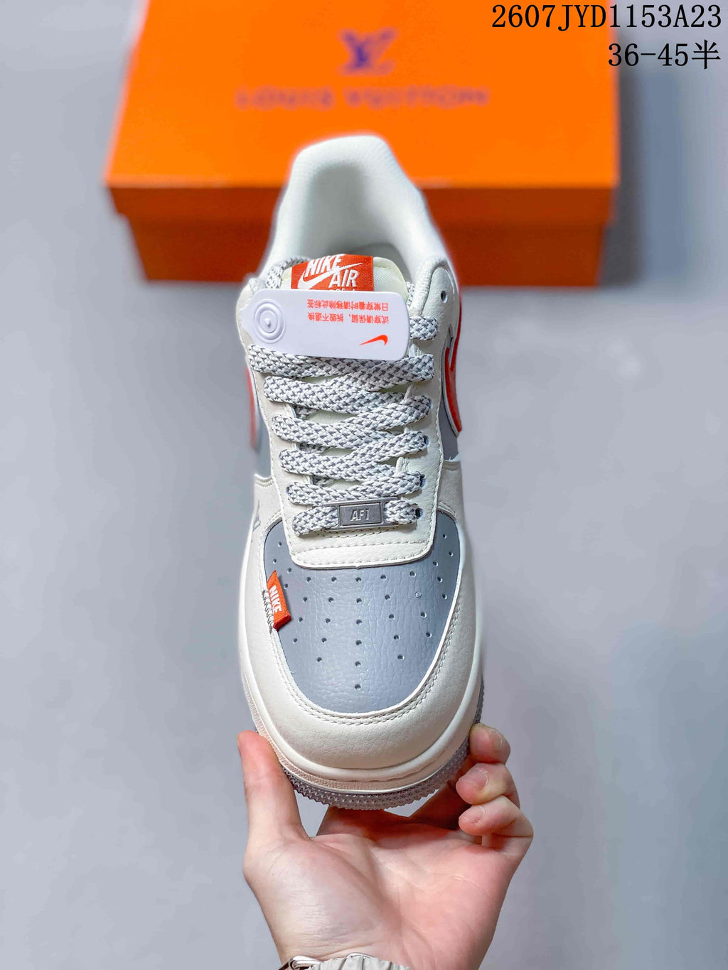 Top view showing the perforated grey toe box, woven laces, tongue branding, and white overlays.