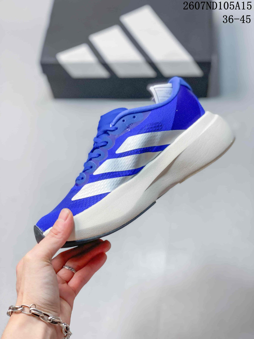 Side profile of the blue and white low-top sneaker showing the layered side stripes and sculpted midsole.