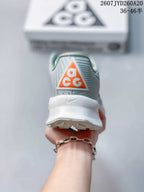 Rear view of a Nike ACG sneaker showing the orange ACG heel logo, padded collar, white heel section, and outsole edge.
