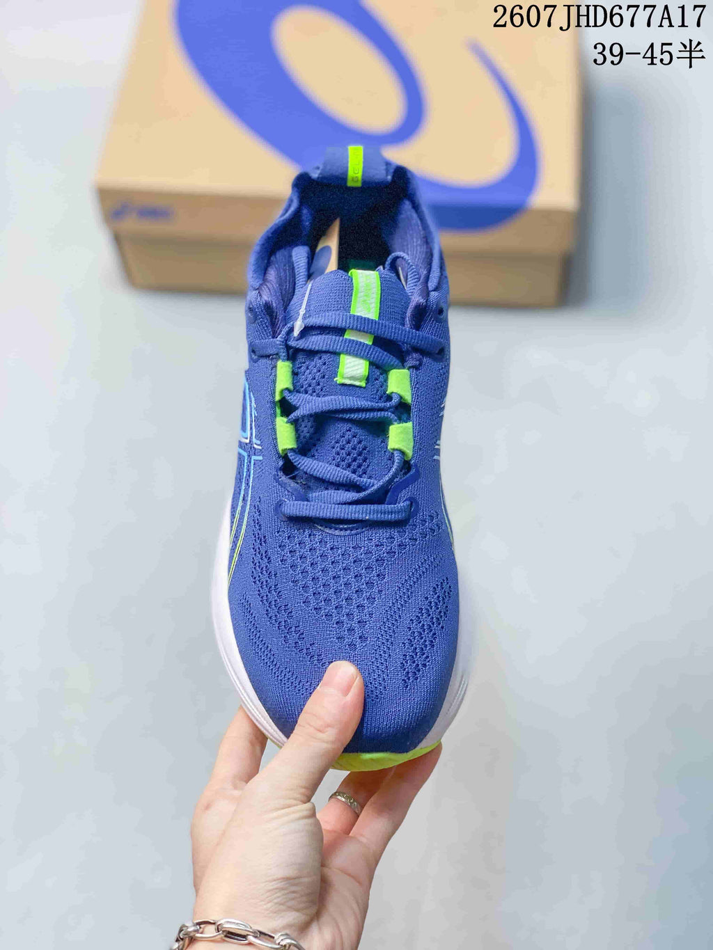 Top view showing the blue textile-style upper, lace system and bright green lace details.