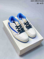 Pair of white and blue low-top sneakers displayed on a white box, showing dark laces and blue collars.
