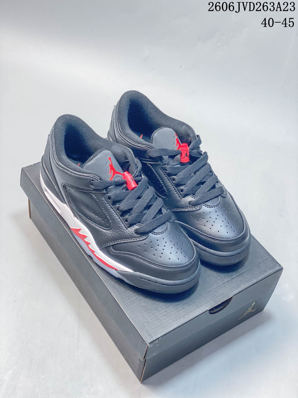 Pair of dark gray Jordan Sixty Plus Low sneakers with white and red accents, shown on a shoebox