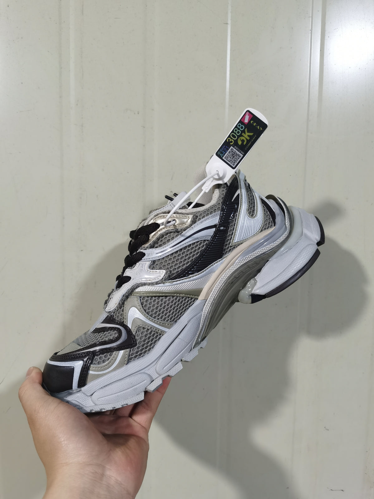 Close-up angled view of white, gray, and black Puma 2000 Runner 2 sneakers with layered panels and black laces.