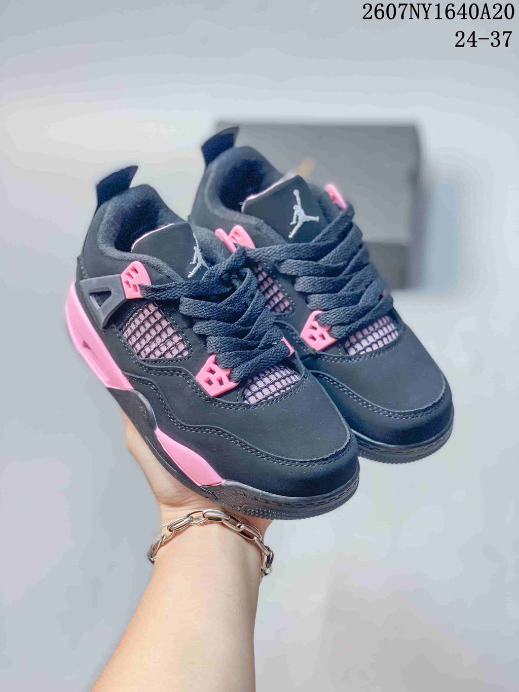 Pair of black and pink low-top kids sneakers shown from the front and side.