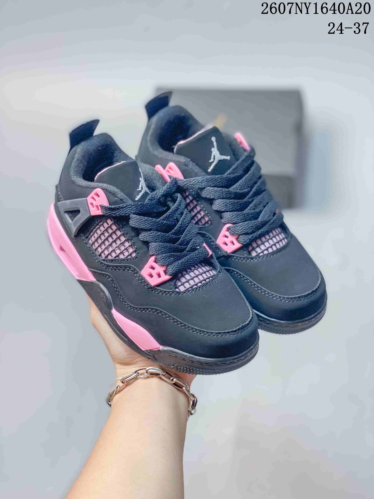 Pair of black and pink low-top kids sneakers shown from the front and side.