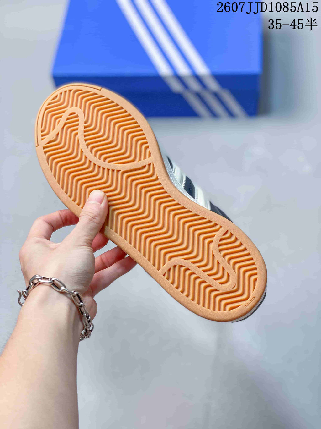 Close-up of the sneaker outsole showing a gum-colored rubber tread with a repeating zigzag pattern.