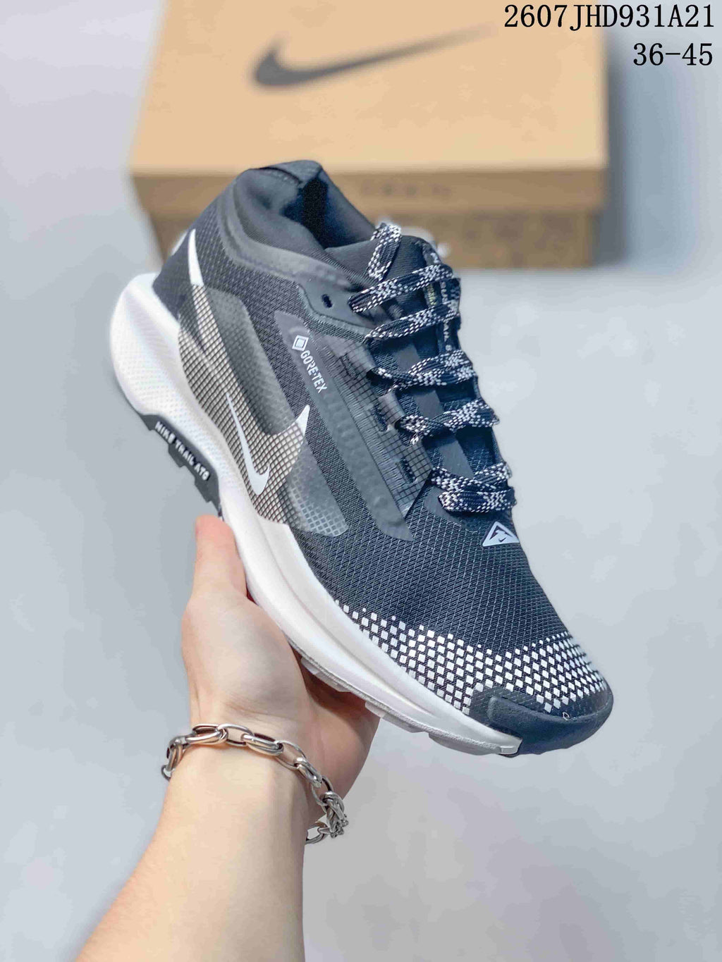 Three-quarter side view showing the dark upper, white side detailing, patterned laces, and contrasting outsole.