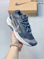 Three-quarter side view showing the dark upper, white side detailing, patterned laces, and contrasting outsole.
