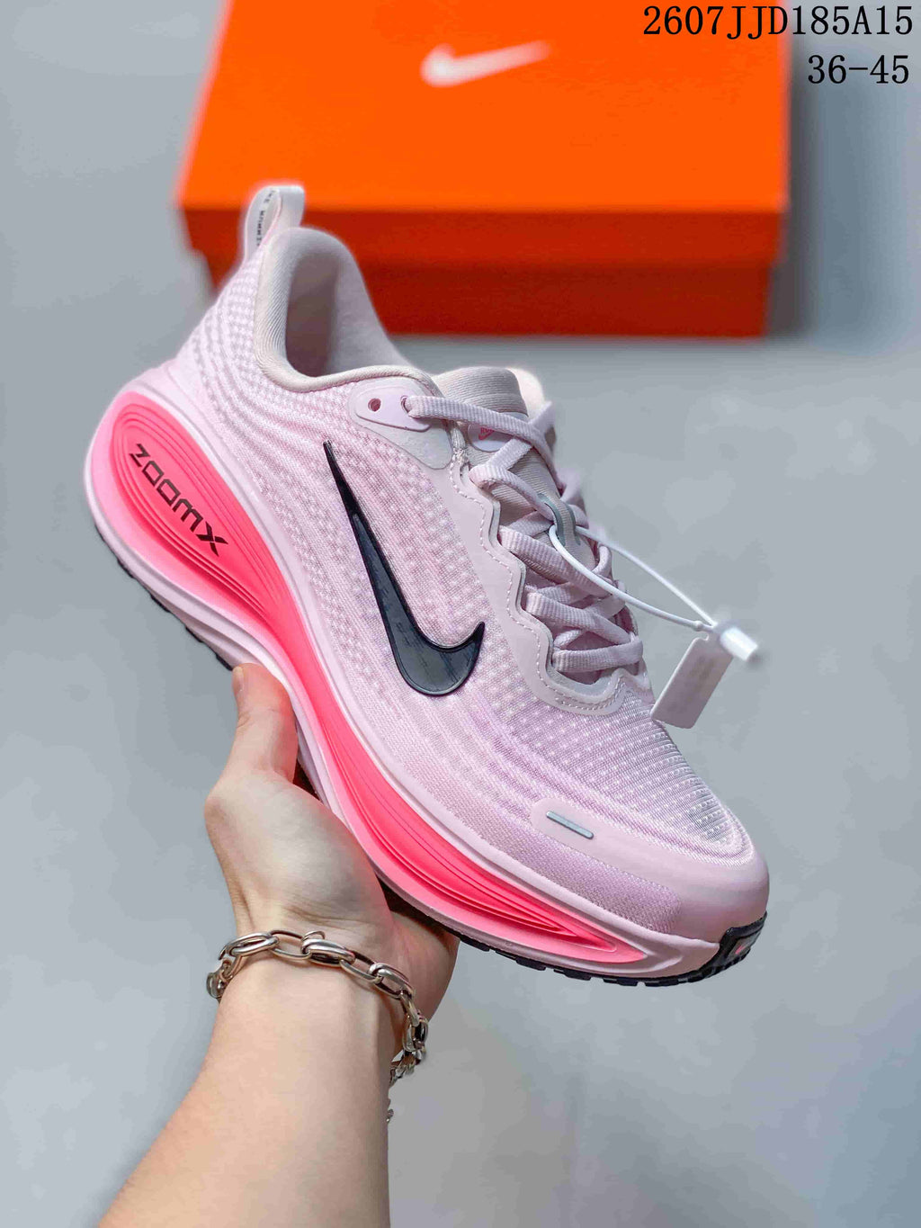Close side view of a pink Nike Vomero Plus sneaker with a contrasting bright sole.