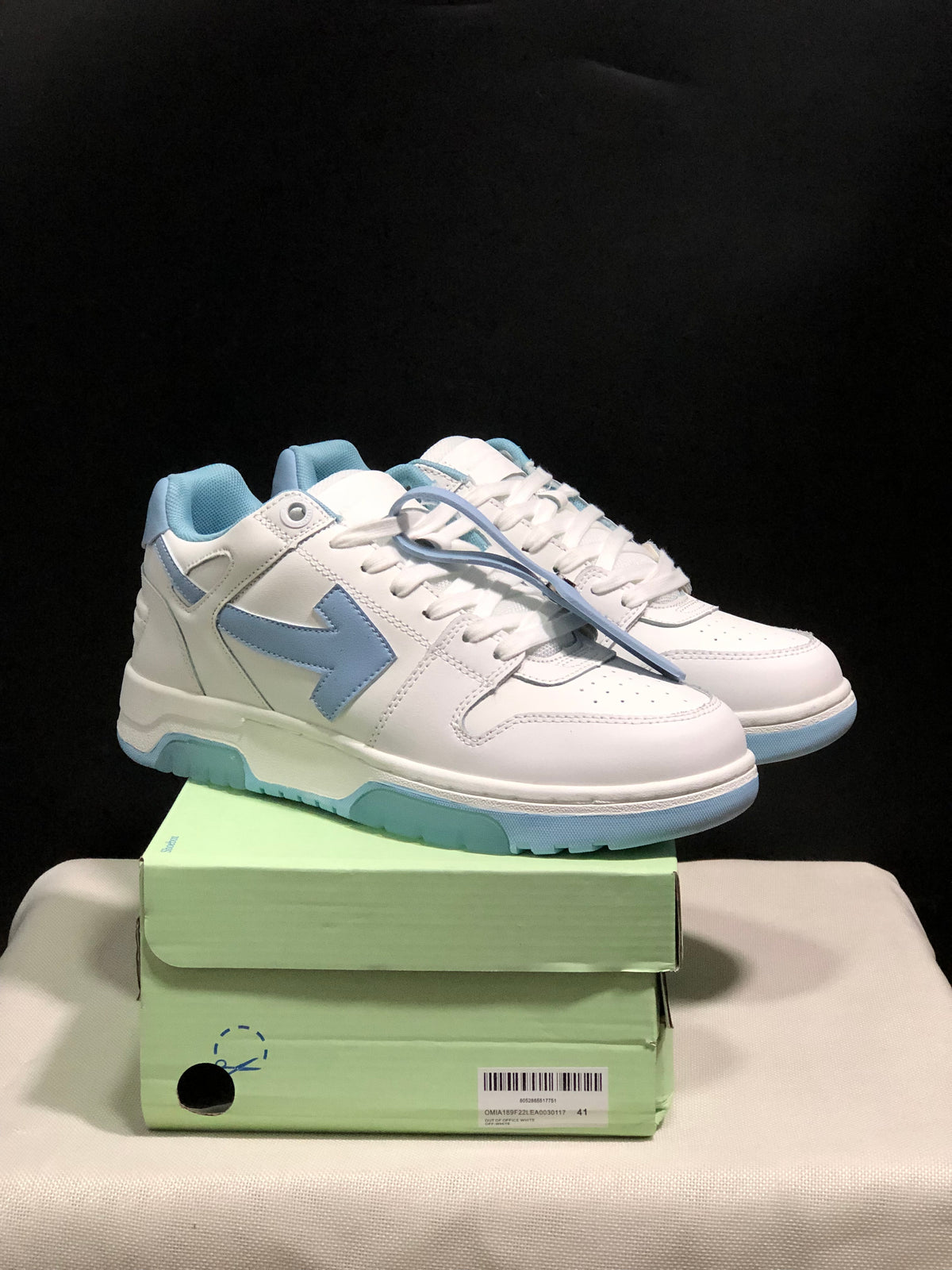 Pair of white and light blue Off-White Out Of Office low-top sneakers displayed on a green shoebox; the box label shows size 41.