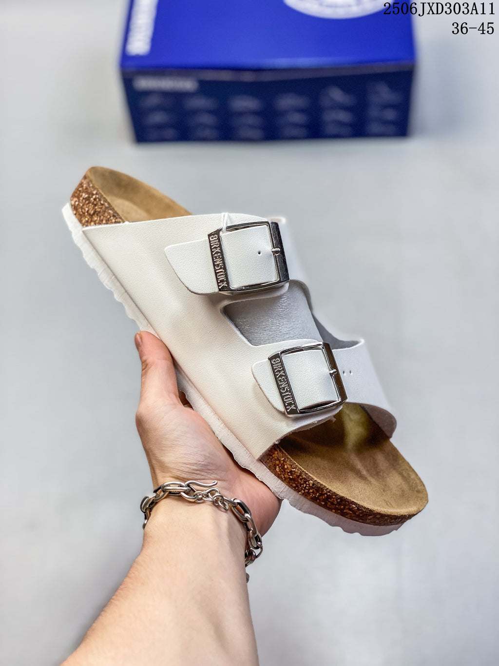 Angled view of a white two-strap sandal with silver-tone buckles
