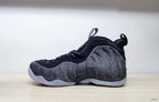 Side profile of a black and grey Nike Air Foamposite Pro Fleece sneaker