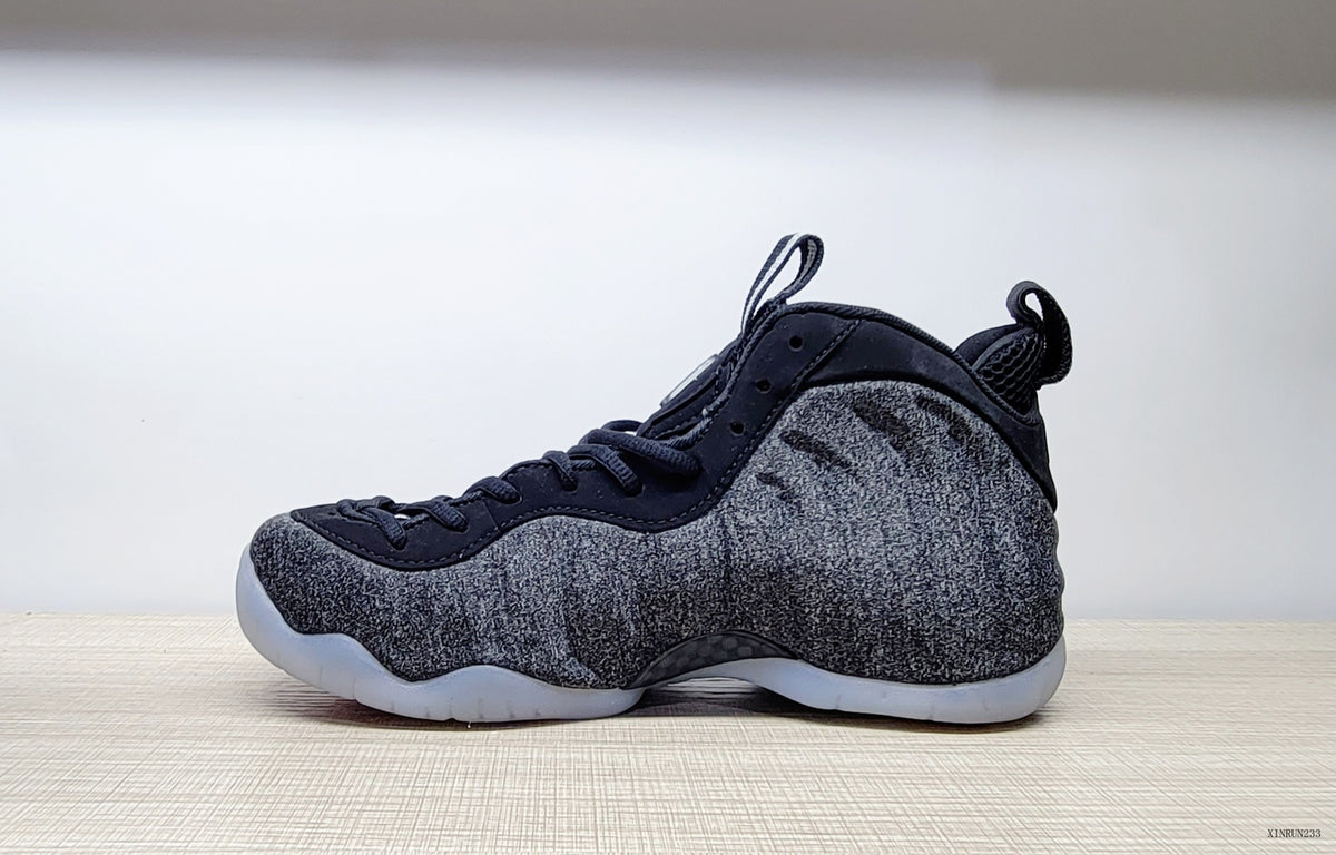 Side profile of a black and grey Nike Air Foamposite Pro Fleece sneaker
