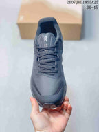 Top view of the sneaker showing the dark gray textured toe box, black laces, padded tongue, and protective toe cap.