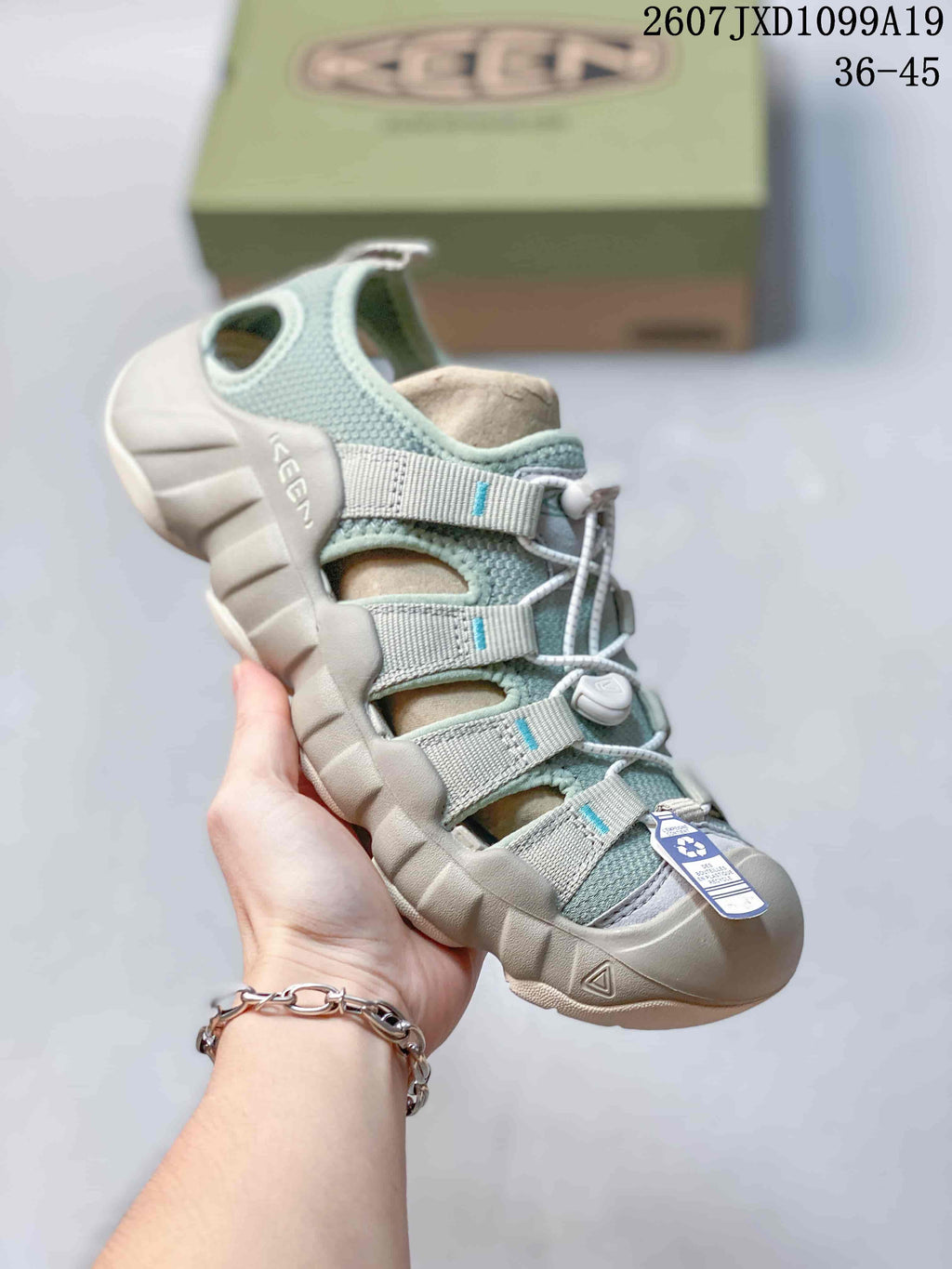 Mint and light gray Keen sandal shown from above with open panels, adjustable straps and a protective toe bumper; the image includes the size range 36–45 and code 2607JXD1099A19.