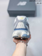 Rear view of a New Balance 9060 sneaker showing the padded heel, layered outsole and blue heel accent.