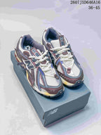 Pair of New Balance 1906A sneakers displayed on a shoebox, showing the multicolor upper and low-top profile.