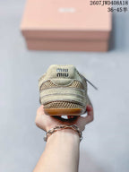 Rear view showing the layered heel construction, mesh panel, and Miu Miu branding on the tongue.
